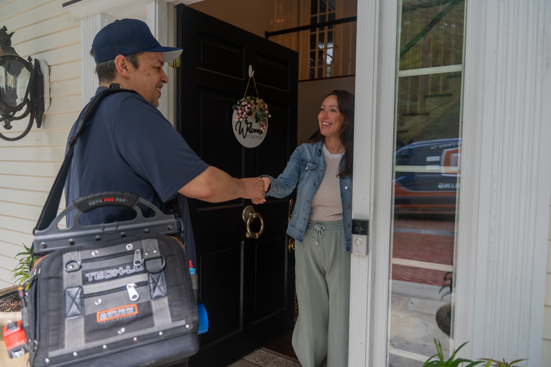 Levco technician greeting a homeowner at her front door