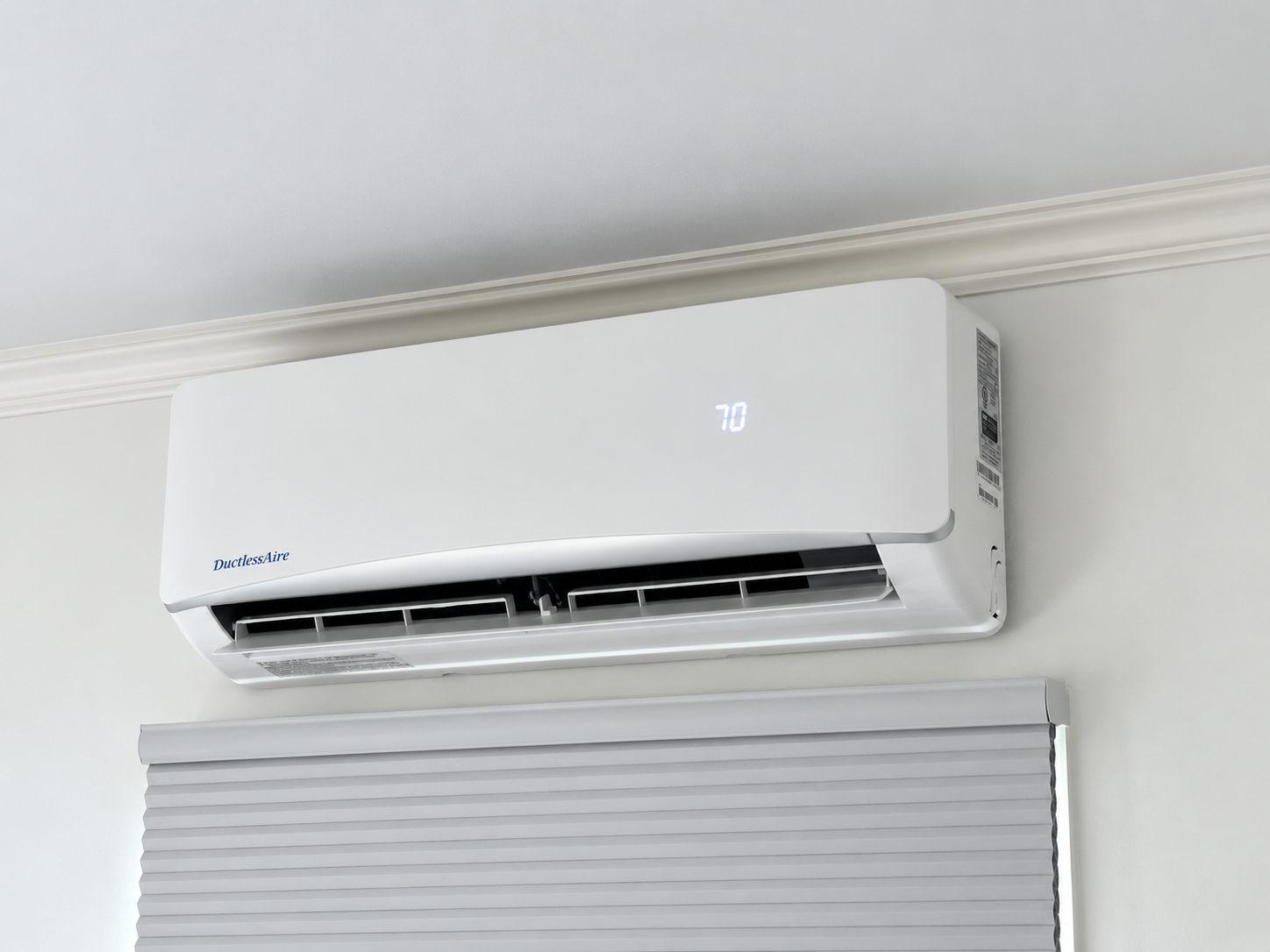 Wall-mounted ductless mini-split indoor head installed above a window