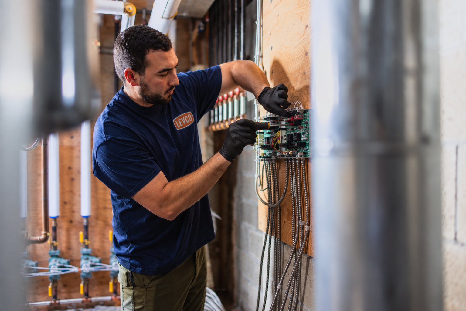 Levco technician diagnosing heating controls during a furnace repair visit