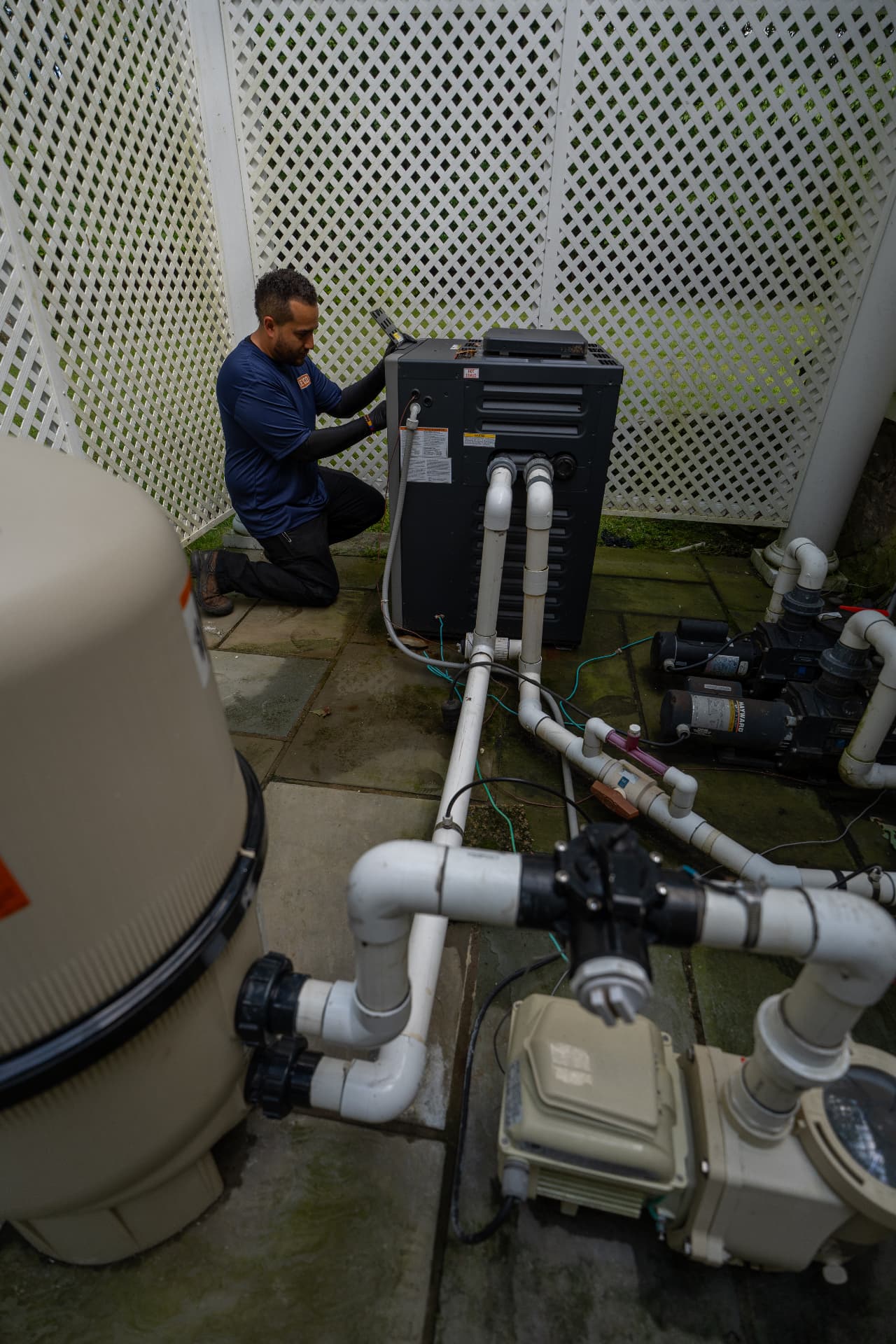 Levco technician checking a pool heater within the complete pool equipment system