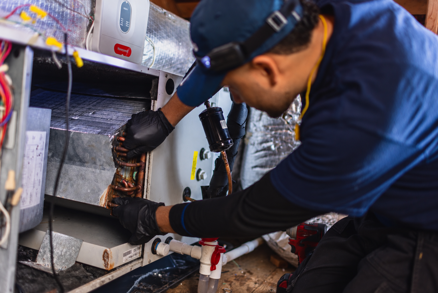Levco technician inspecting the coil and refrigerant components inside a residential air handler