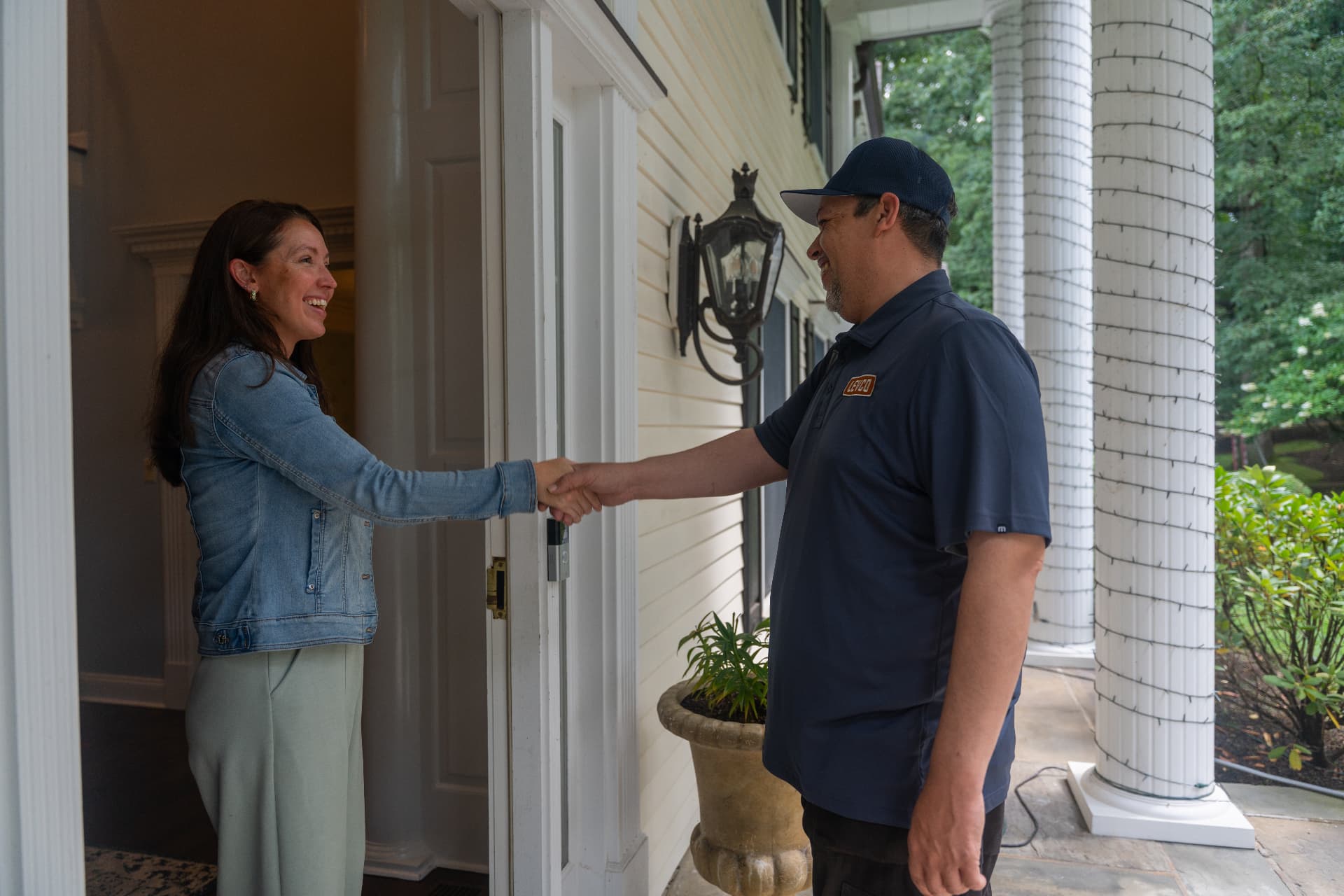 Levco technician greeting a homeowner at her front door