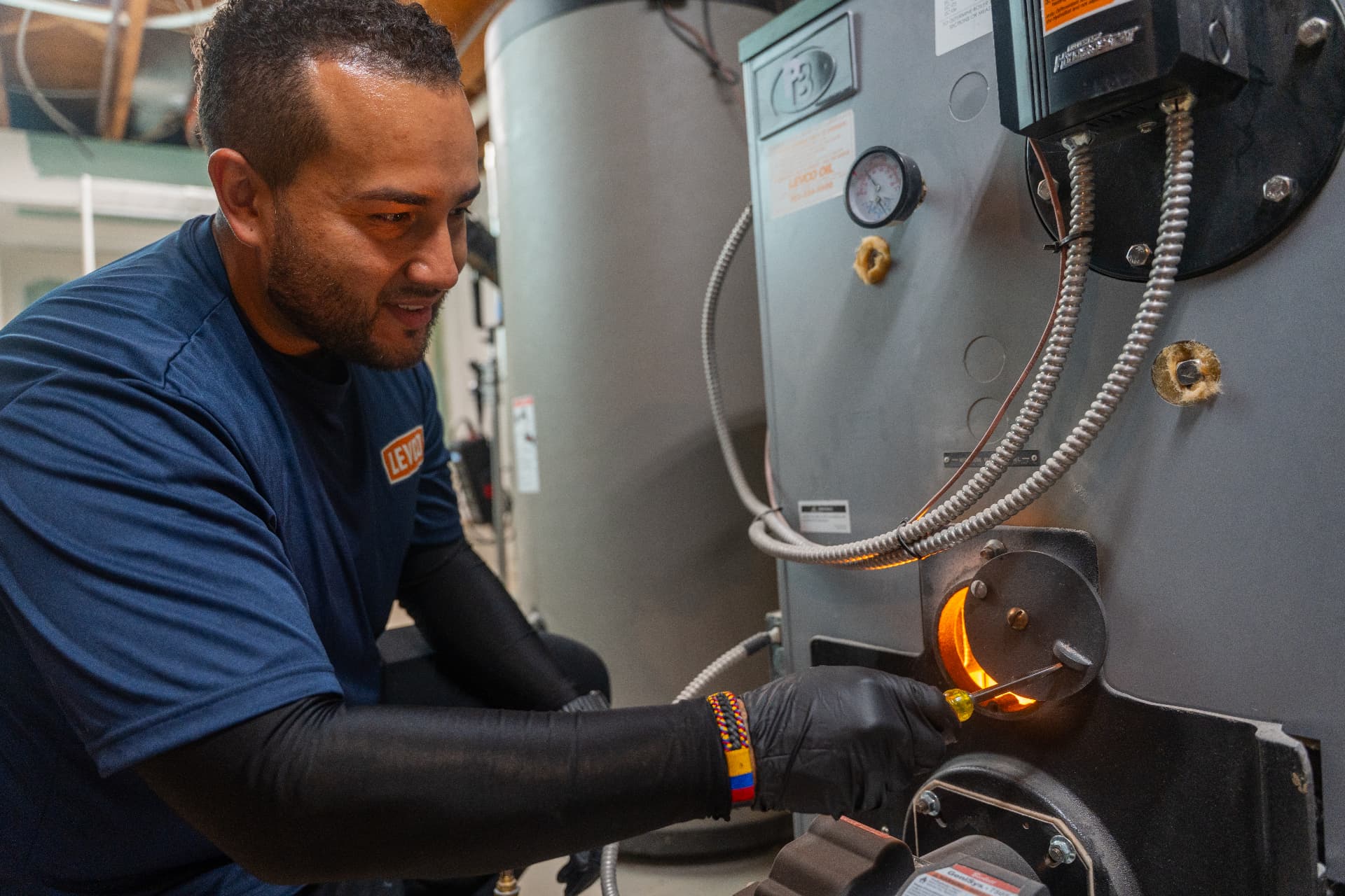 Levco technician inspecting the burner flame during a heating repair