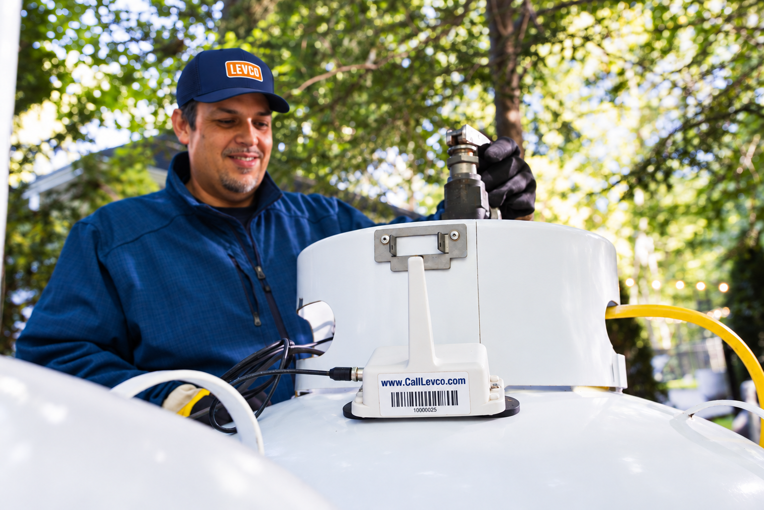 Levco technician checking a residential propane tank equipped with a wireless monitor