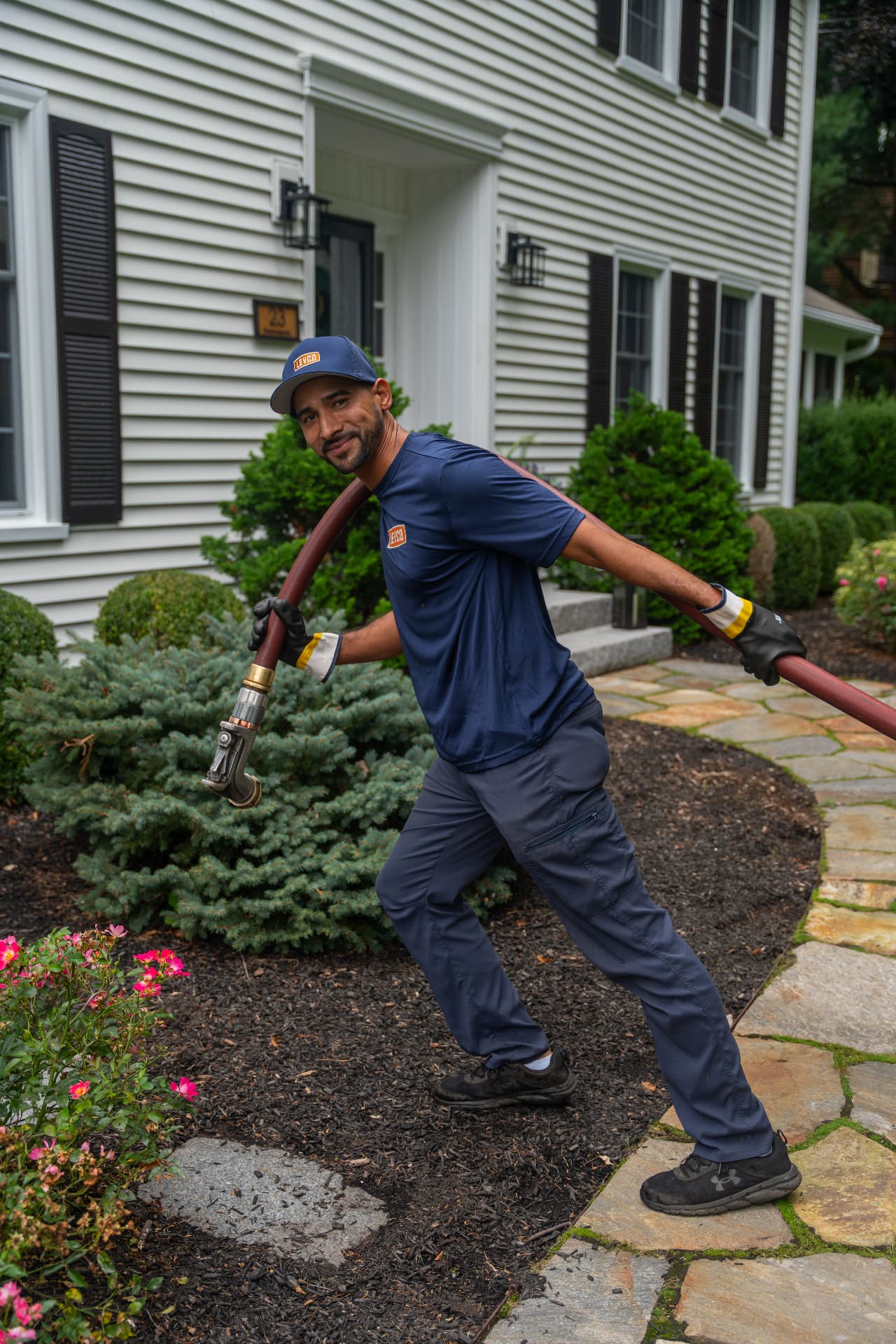 Levco driver carrying the delivery hose up the walkway to a Connecticut home