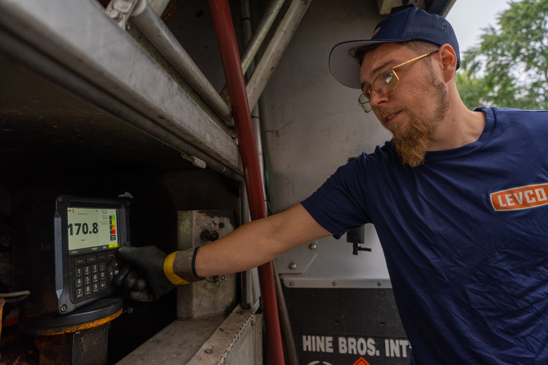 Levco driver reading the metered gallons on the delivery truck's register