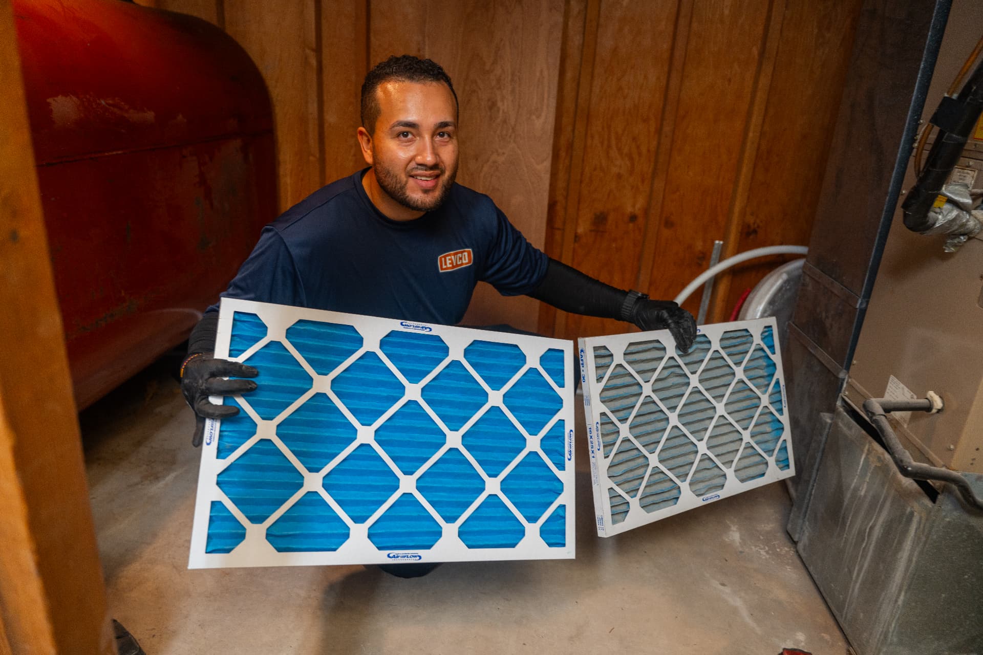 Levco technician showing a clean air filter beside the filter being replaced