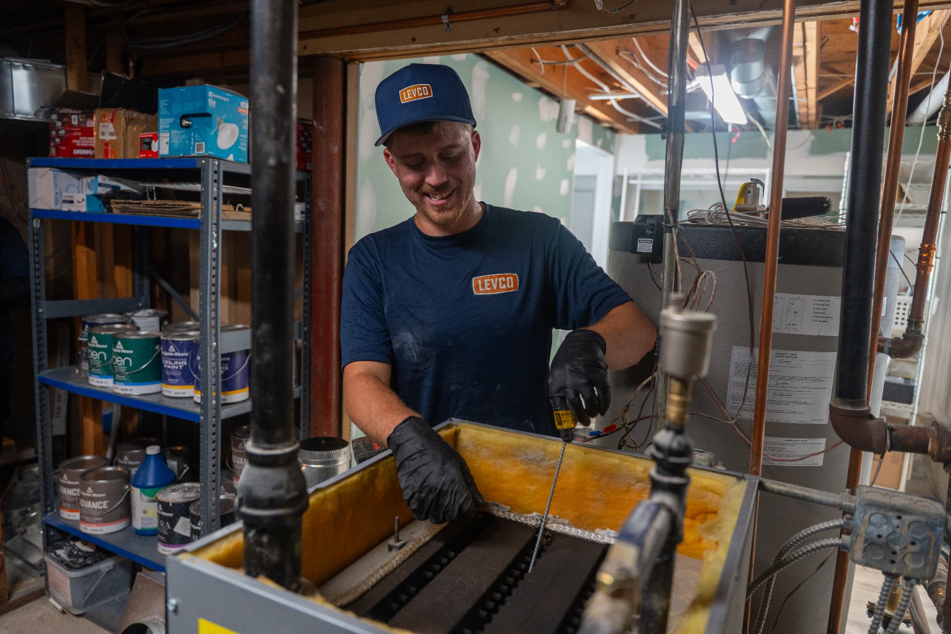 Smiling Levco technician cleaning a residential boiler during a maintenance visit