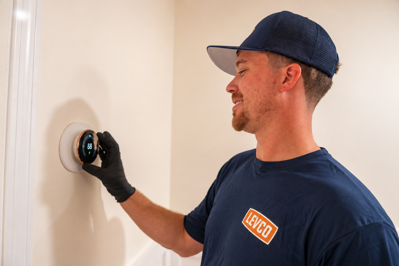 Levco technician checking a smart thermostat during a no-heat visit