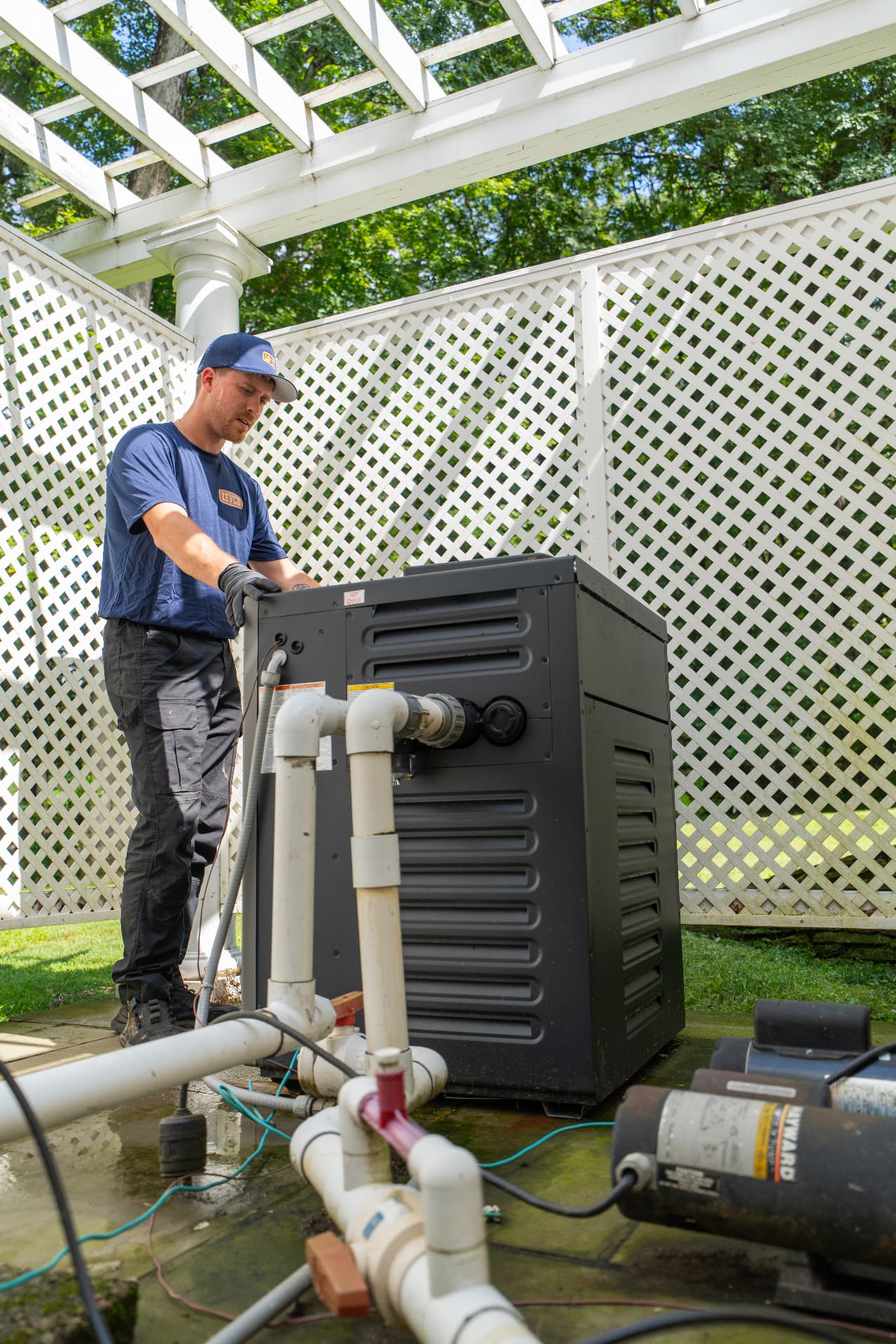 Levco technician servicing a pool heater and its connected plumbing