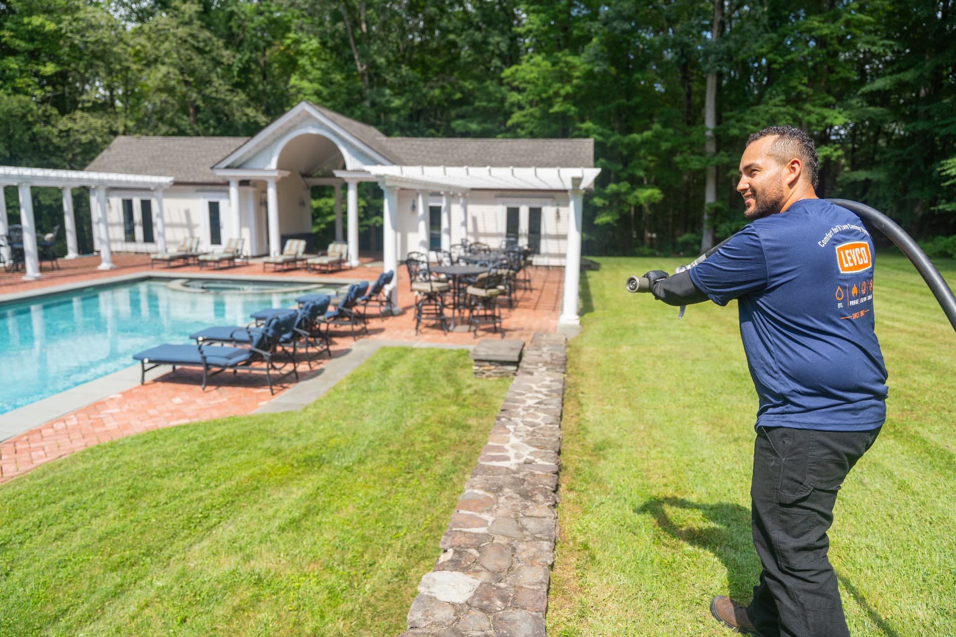 Levco technician managing a propane delivery beside a pool at a Connecticut home