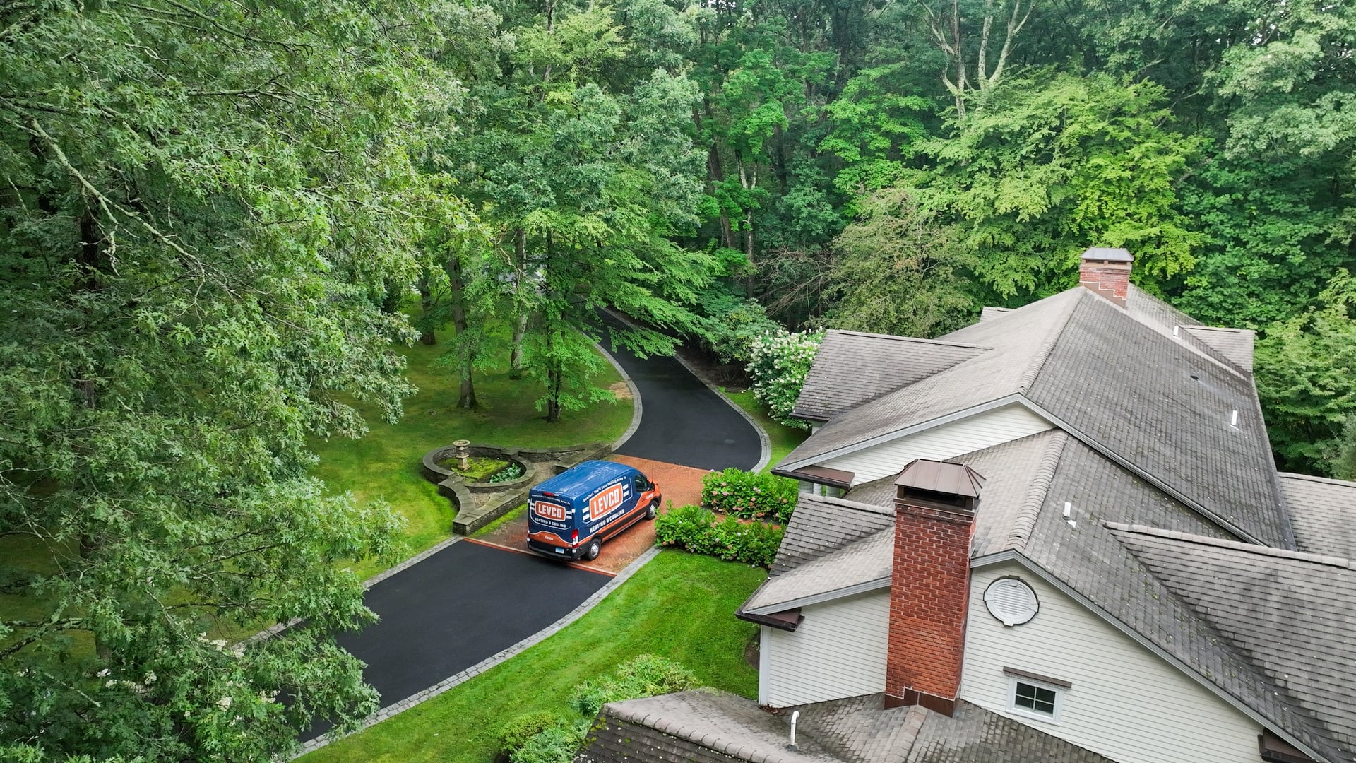 Aerial view of a Levco service van parked at a Connecticut home surrounded by trees